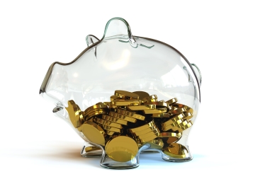 Glass piggy bank filled half-full of gold coins