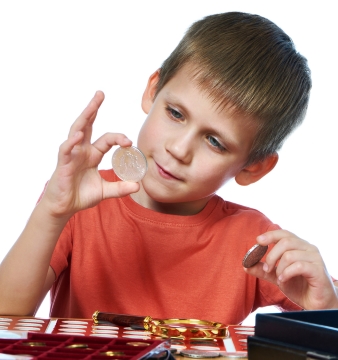 Boy holding and looking at silver coin